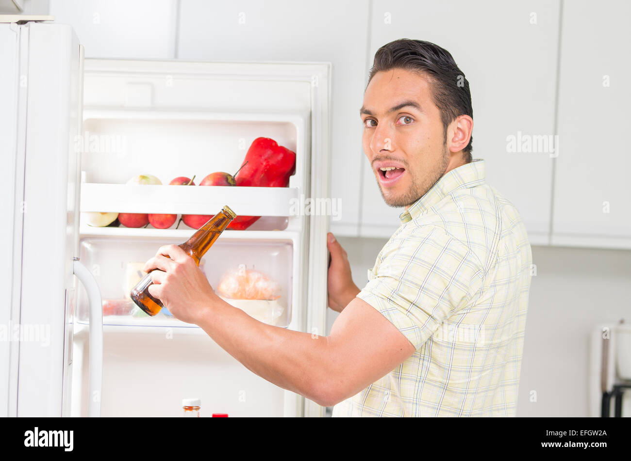 young handsome man looking for food in the fridge Stock Photo