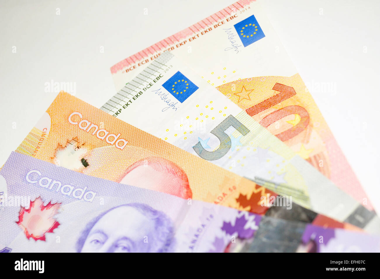 A collection of Canadian Dollars and European Euro notes against a white background Stock Photo