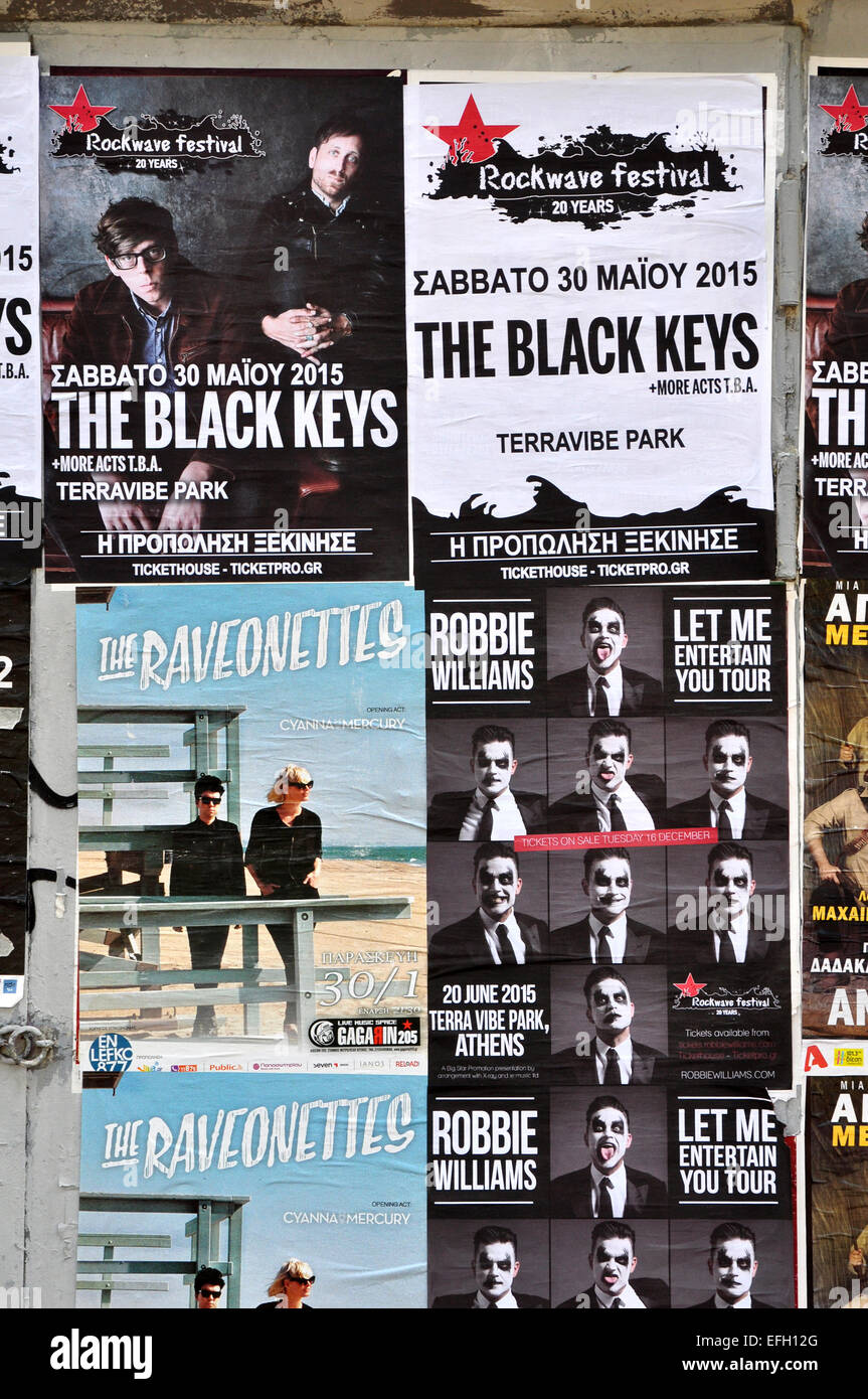 City wall covered with concert posters for upcoming live music shows by The Black Keys, Raveonettes and Robbie Williams. Stock Photo