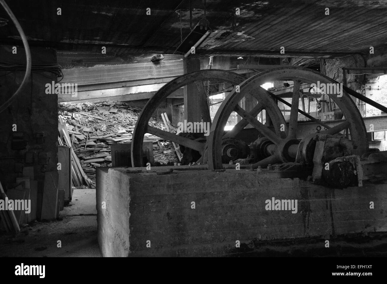 Rusty machinery in abandoned factory interior. Black and white. Stock Photo