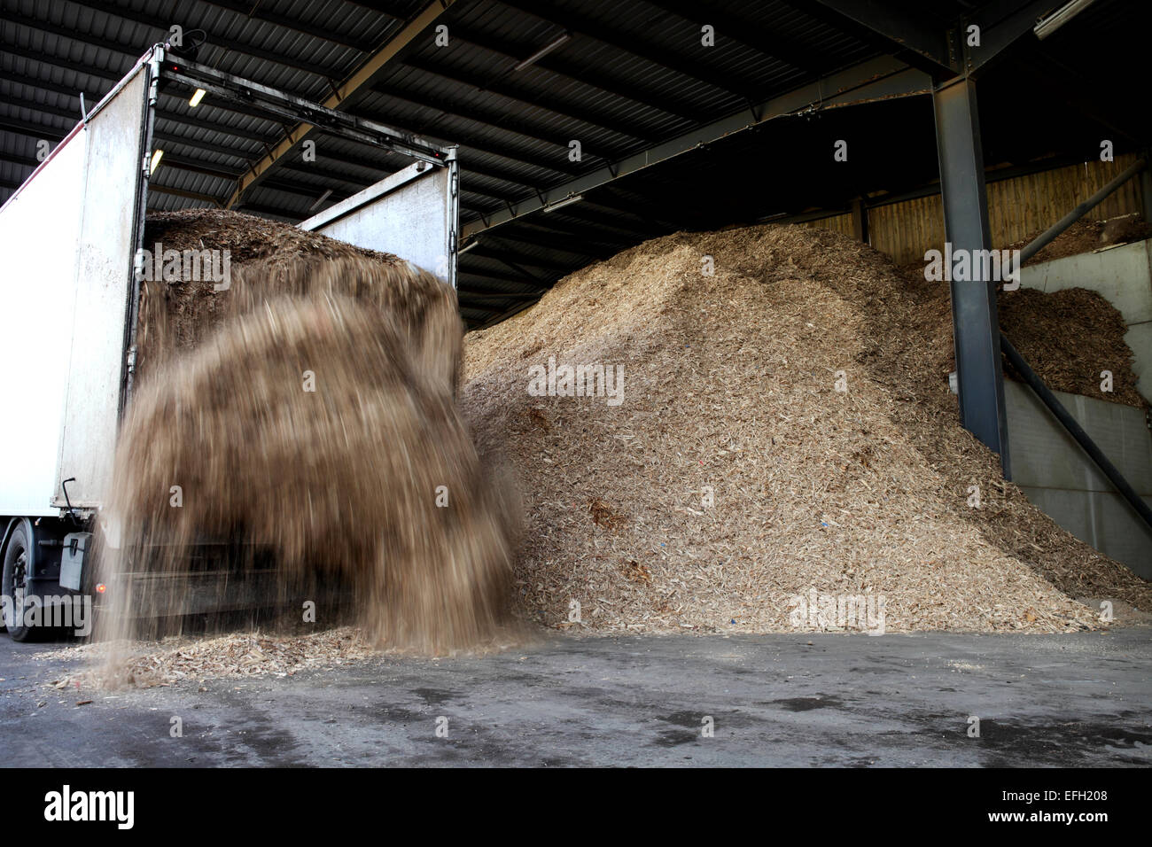 Lorry unloading forestry waste in loading bay at biomass plant Stock Photo