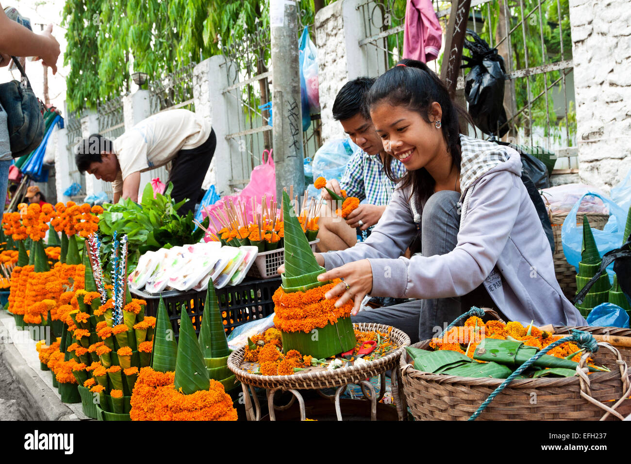 Lao young lady selling special arranged flowers for Lao New Year (Pii