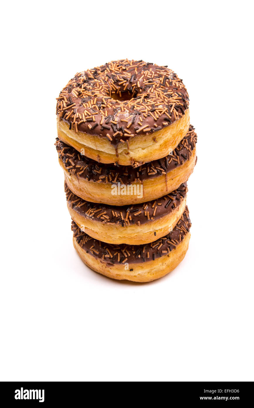 A pile of chocolate iced ring donuts on a white background Stock Photo