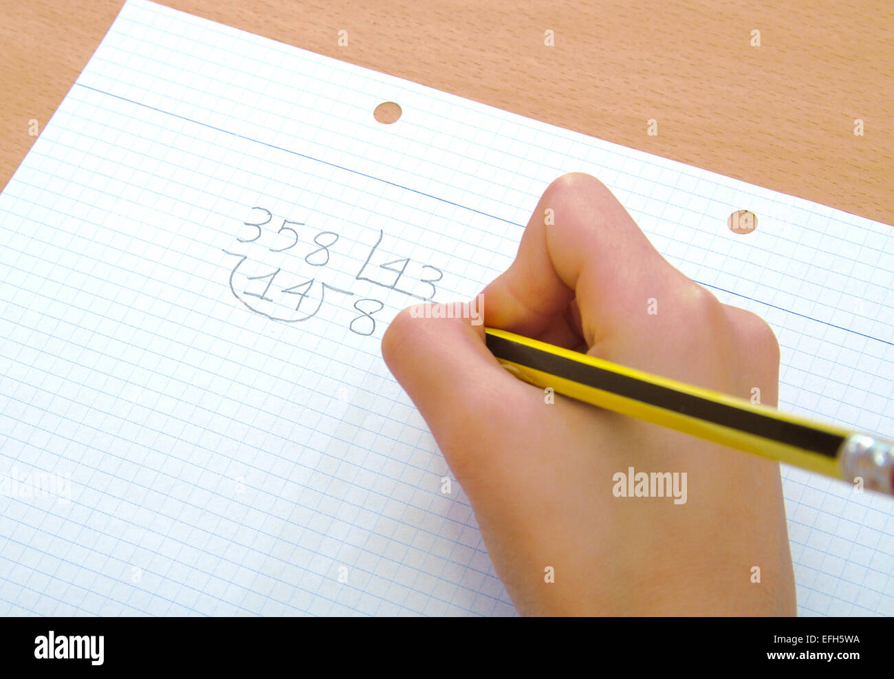 Closeup on the hand of a child doing a math division at school Stock Photo