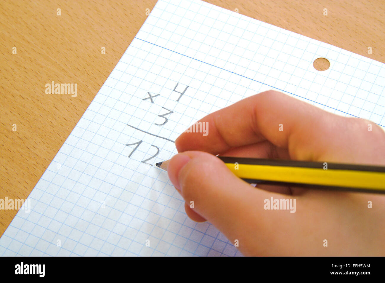 Child doing a math multiplication as homework Stock Photo