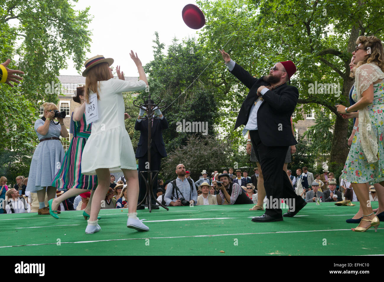 The 10 Anniversary of the Chap Olympiad. A sartorial gathering of chaps and chapesses in Bloomsbury London. Various Chap sports are held at a picnic in the square. Here people compete in Beach Volleybowler: volleyball with a red bowler hat, London, England Stock Photo
