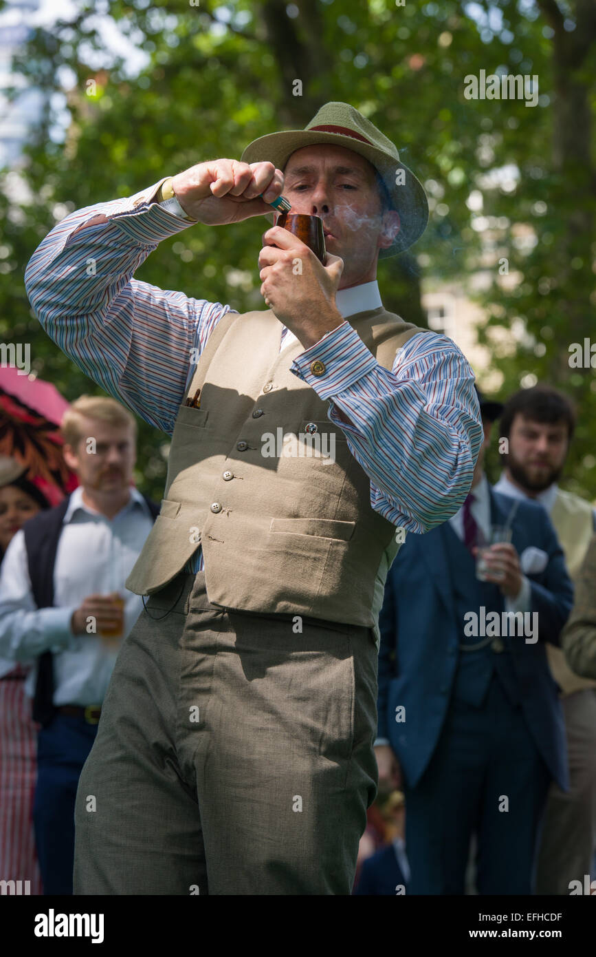 Organiser Gustav Templelighting the opening pipe to launch the 10 Anniversary of the Chap Olympiad. A sartorial gathering of chaps and chapesses in Bloomsbury London. Various Chap sports are held at a picnic in the square, London, England Stock Photo