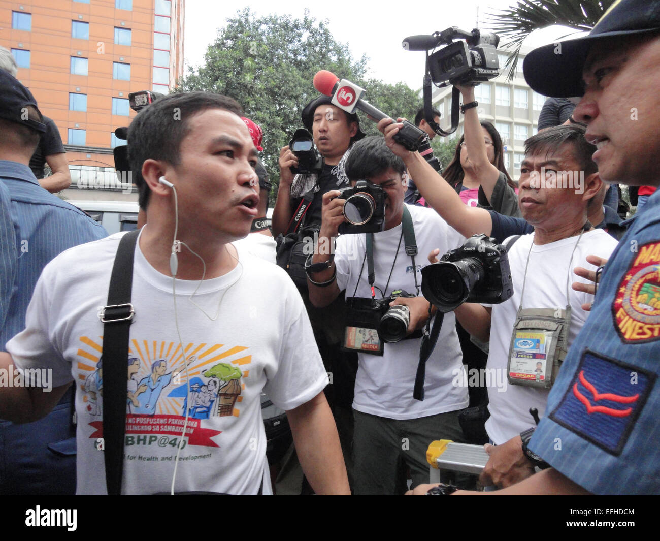 A protester confronts a police officer after spraying a message on the center aisle along Roxas Boulevard, near the US Embassy. Protesters accused President Benigno Aquino III, suspended police chief Alan Purisinma, and the US government of being involved in the botched anti-terror operation that killed 44 police commandos, 18 Moro rebels, and 7 civilians. The protest was held on the 116th anniversary of the Filipino-American War that claimed at least 600,000 lives. © Richard James Mendoza/Pacific Press/Alamy Live News Stock Photo