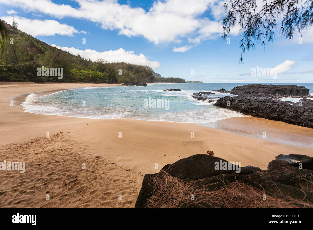 Isolated Beach swept deeply by the waves. A round and protected bay at the end of Lumaha'i Beach on the north coast. Stock Photo