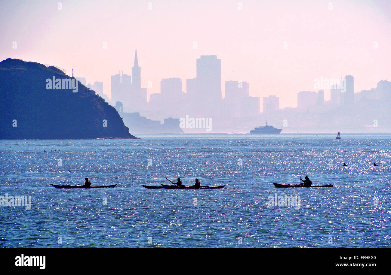 kayakers paddle on San Francisco Bay in Tiburon Caliofornia with angel island and the skyline of San Francisco in the background Stock Photo