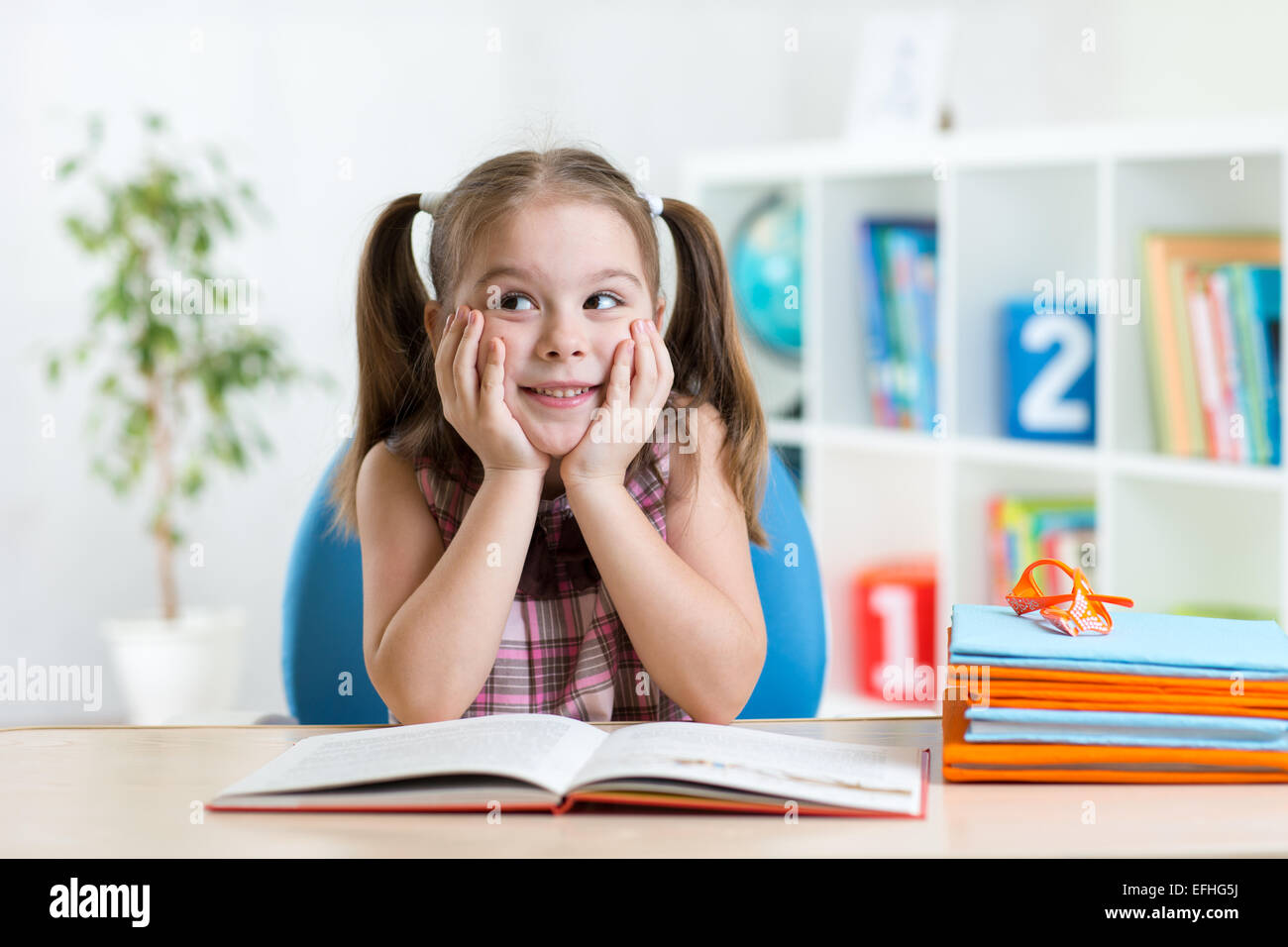 smiling child girl reading book at home Stock Photo Alamy