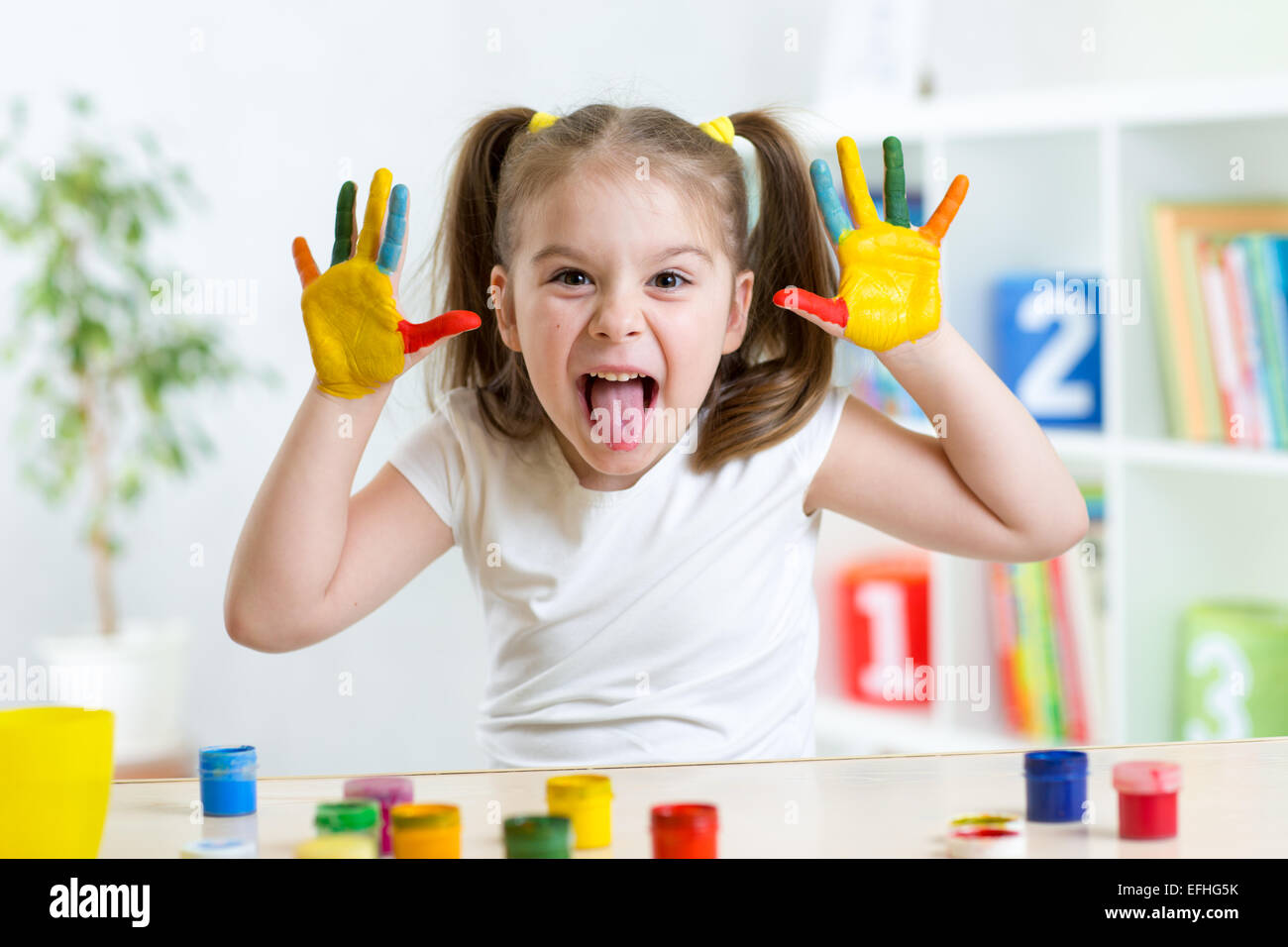 Funny kid with hands painted in colorful paint Stock Photo