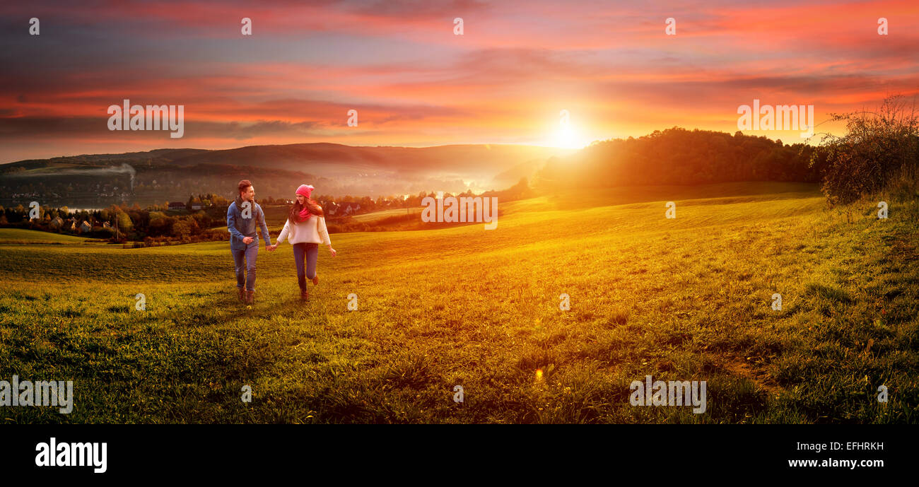 Loving couple holding hands running on the field. beautiful landscape Stock Photo