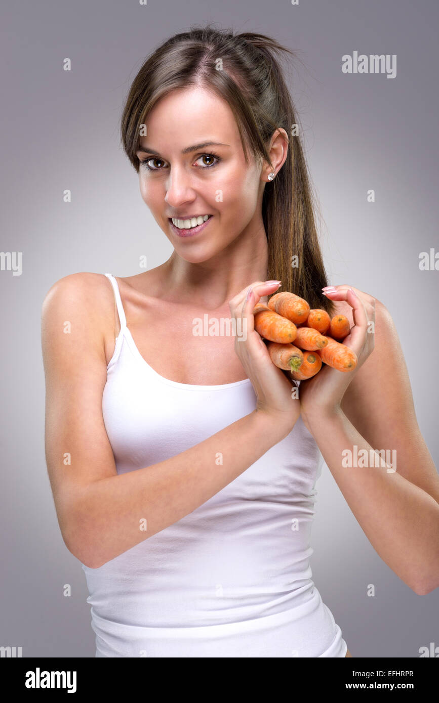 Healthy lifestyle! Beautiful woman holding lots of carrots heart shape Stock Photo