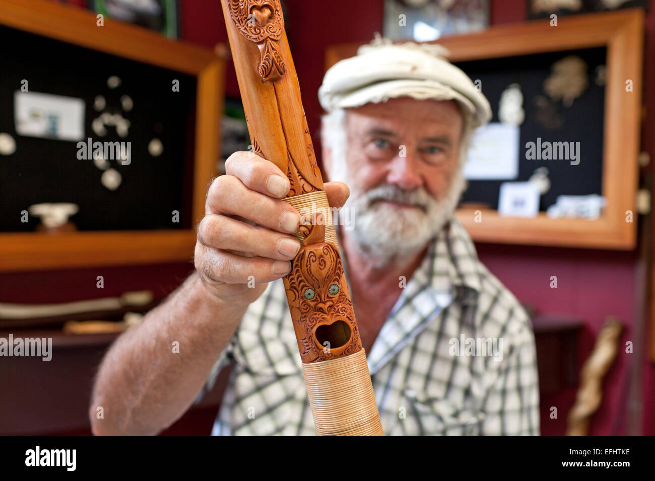 Master carver Brian Flintoff with wooden carved, mythical figures on a flute, Instrument maker, Maori Music, South Island, New Z Stock Photo