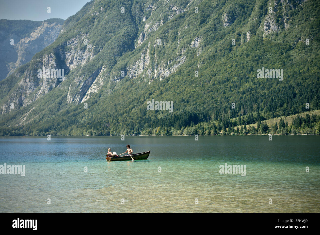 Man, woman and dog with boat at Lake Bohinj, Triglav National Park, Julian Alps, Gorenjska, Slovenia Stock Photo