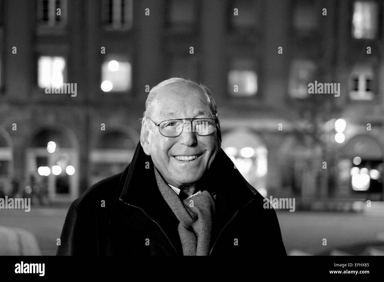 Black and white portrait of a smiling elderly man 80s at night, street, Stock Photo