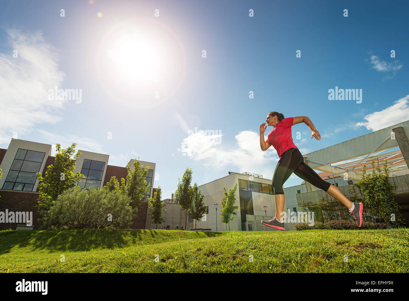 Running woman. outdoors, behind buildings Stock Photo