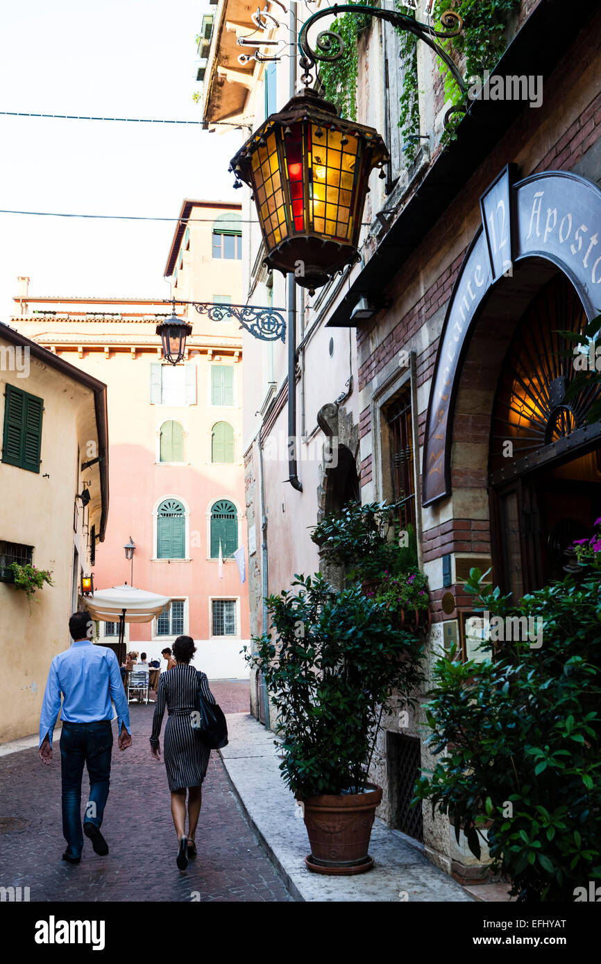 Couple passing a restaurant, Verona, Veneto, Italy Stock Photo