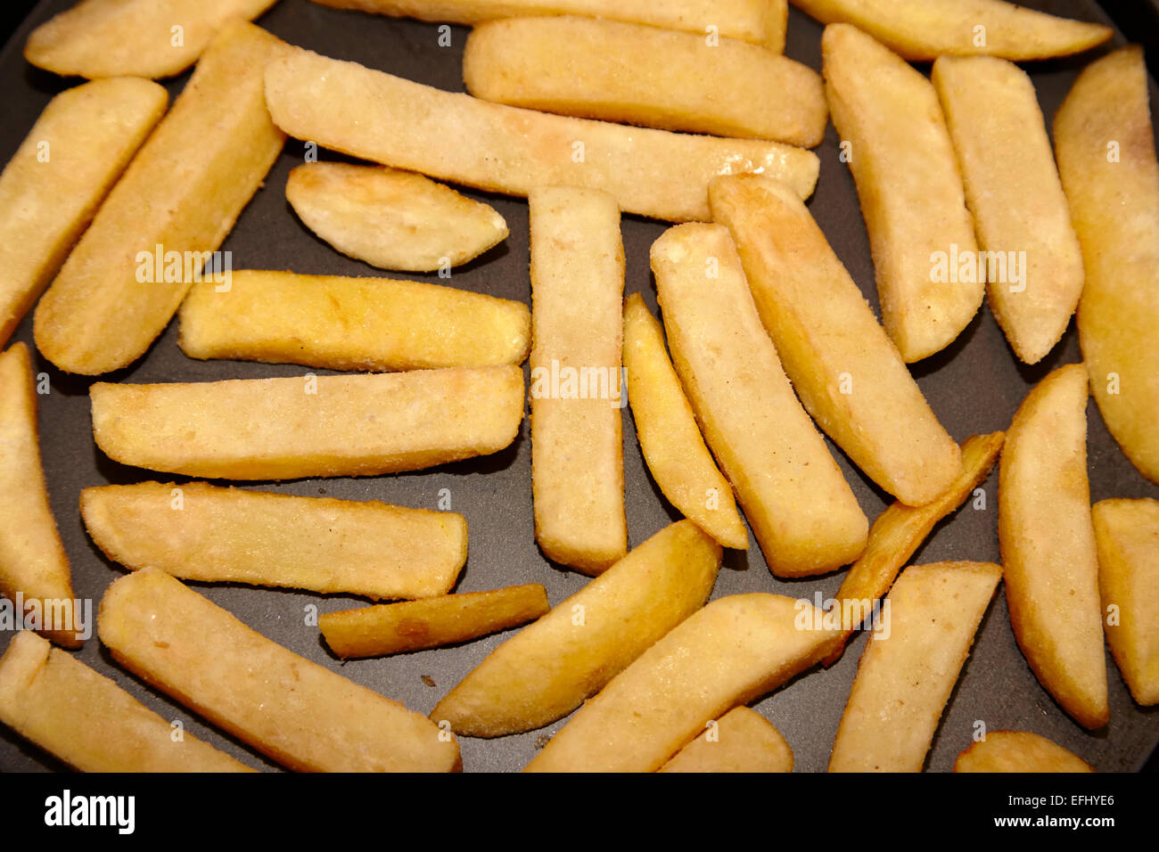 frozen oven chips laid out on a baking tray Stock Photo