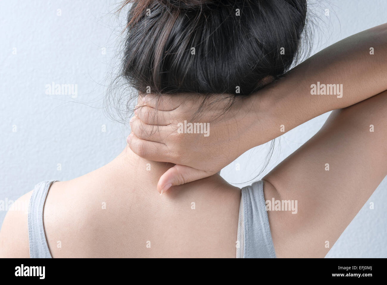 Woman Massaging Neck, Rear view Stock Photo