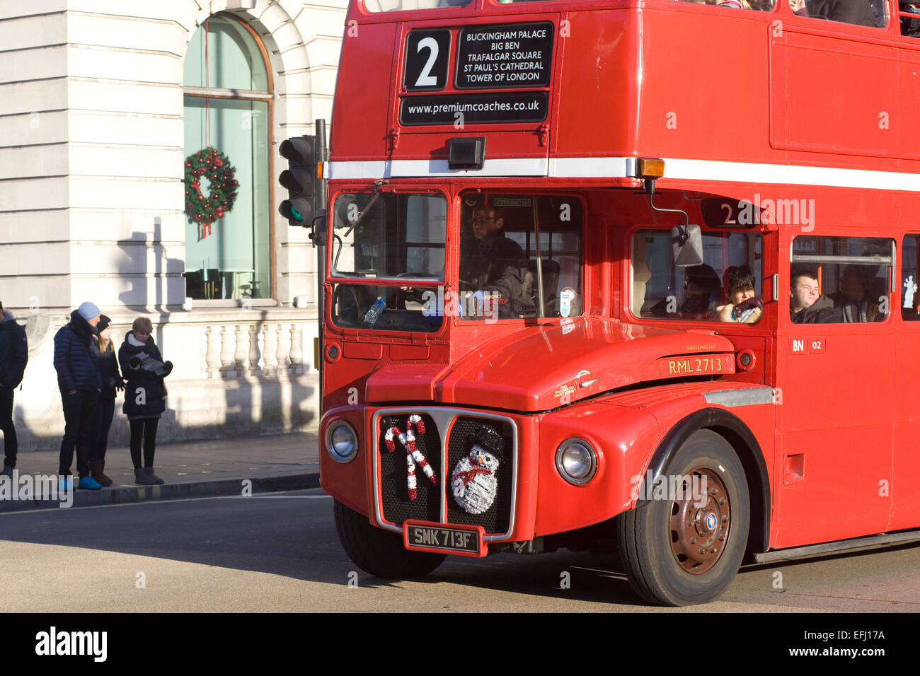 London Double decker bus with snowman and candy cane Christmas decorations on the front Stock Photo