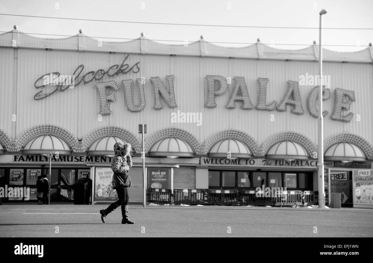 Blackpool Lancashire UK - Woman walks past the deserted Silcocks Fun Palace on cold winters day Stock Photo