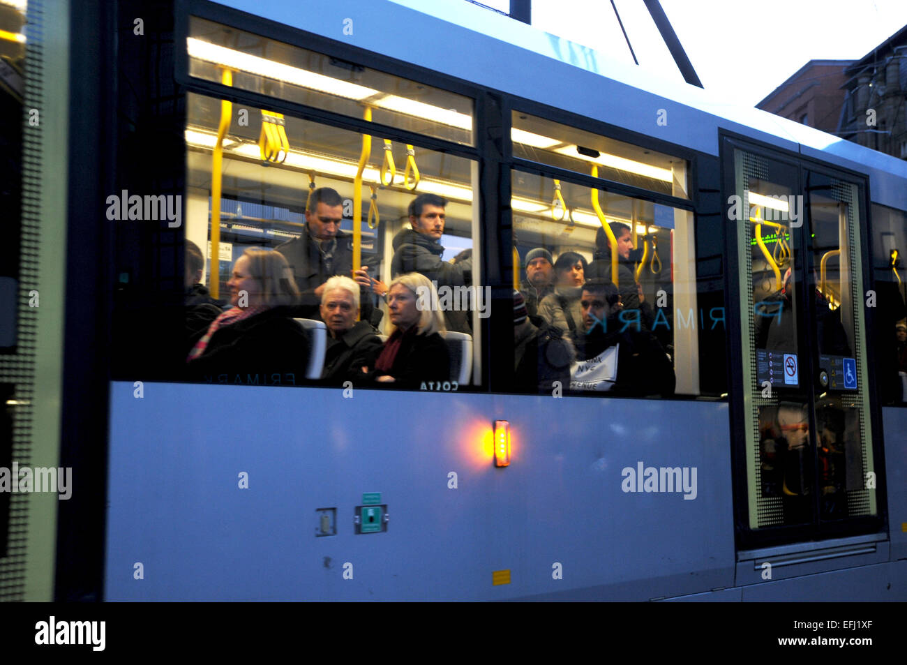 Manchester Lancashire UK - Commuters on a city centre tram at night looking out of the window January 2015 Stock Photo