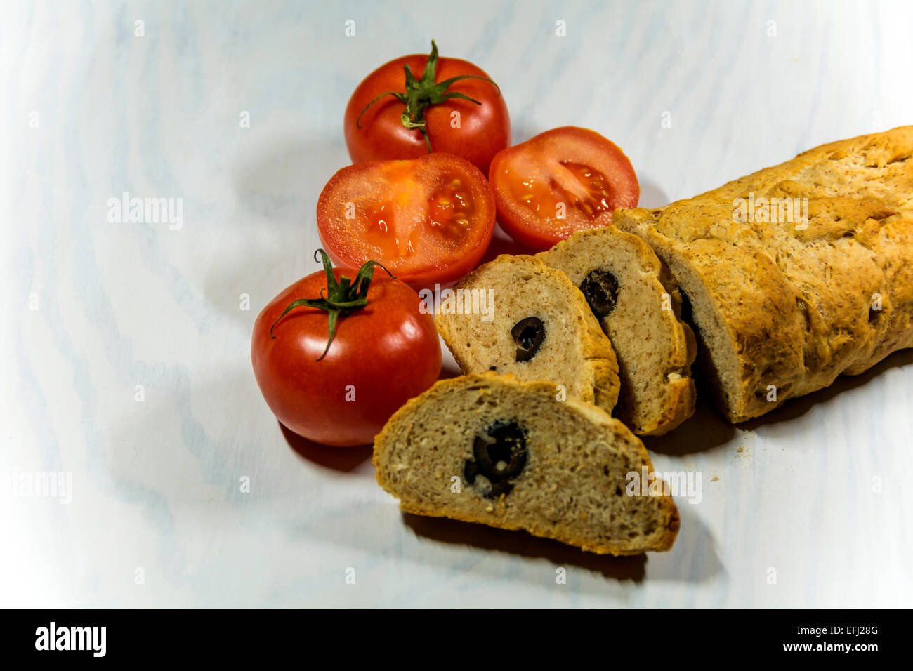 Home made olive bread from an Italian recipe, served with tomatoes. Stock Photo