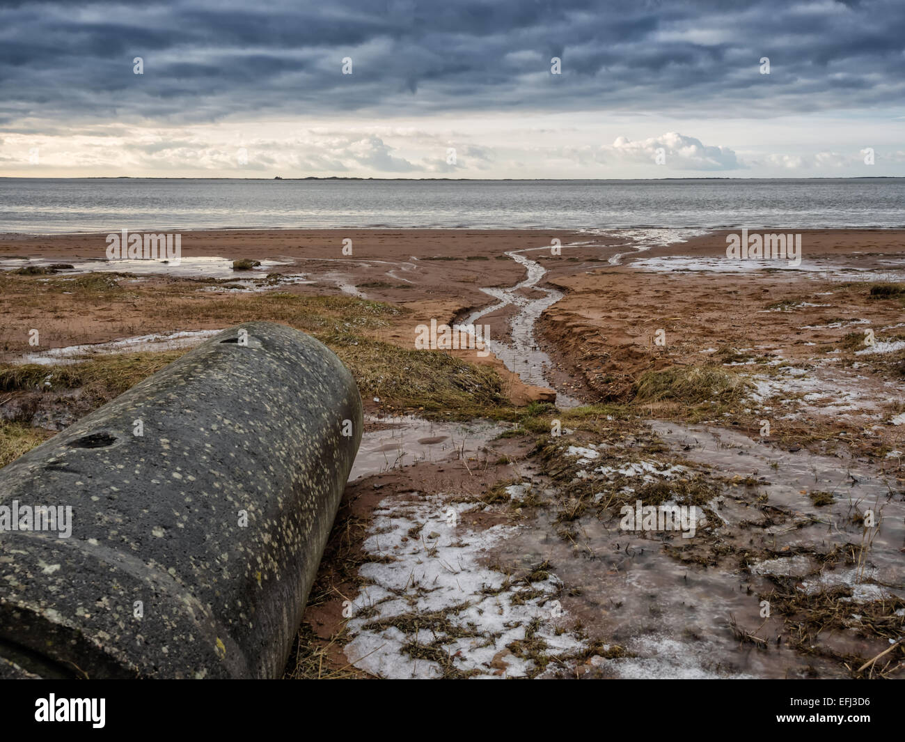 Water outlet pipe on an empty beach Stock Photo