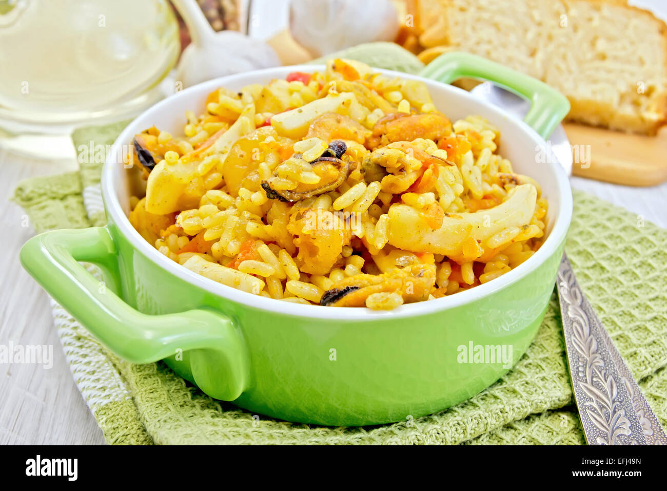 Pilaf with seafood in green pot on board Stock Photo Alamy