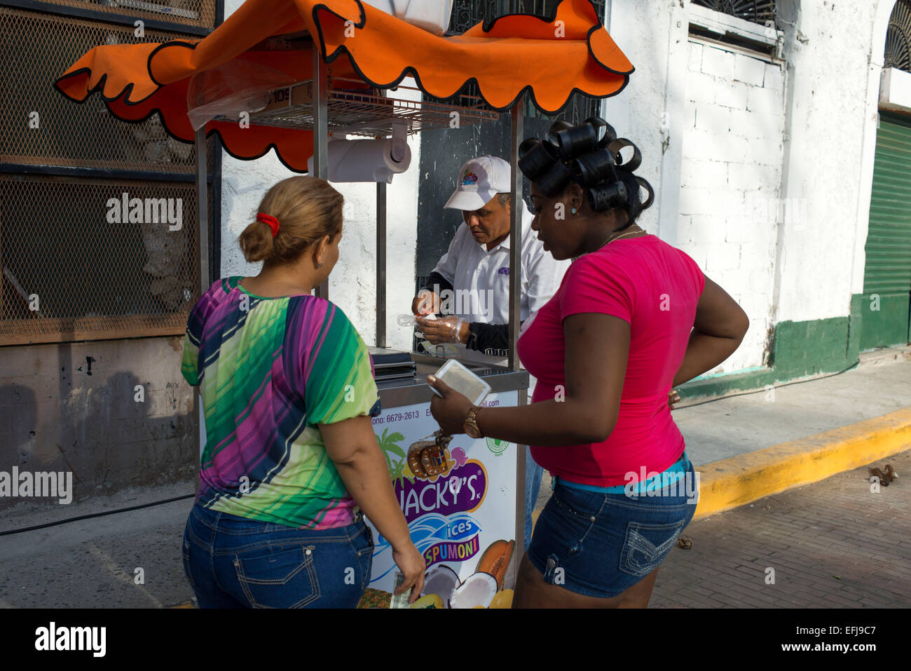 Local girls buying ice cream at a street stall selling ice cream in Casco Antiguo Historic Town Panama City Central America old Stock Photo