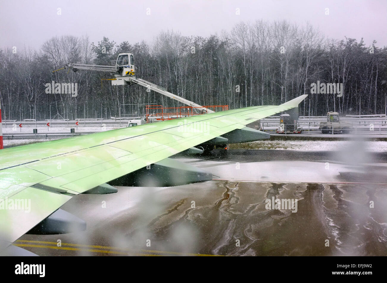 Deicing the wings of a commercial airliner at Frankfurt airport in winter. Stock Photo