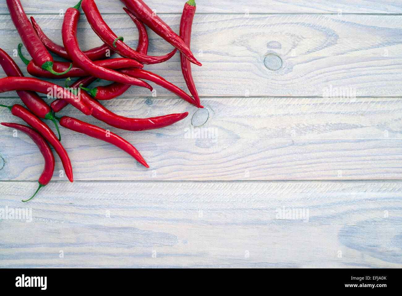 Red peppers on a wooden table painted white. Space for text Stock Photo