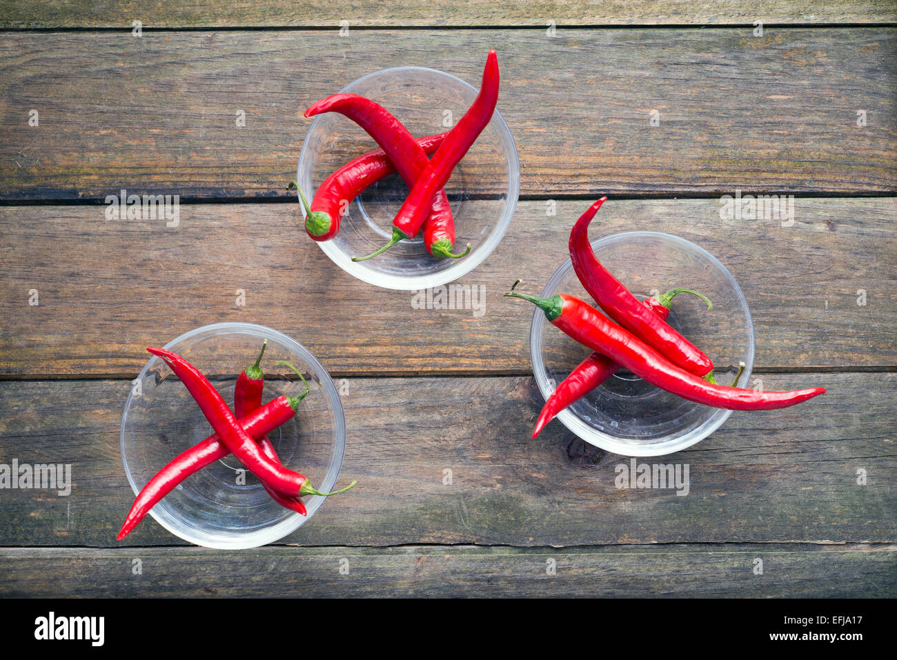 three glass bowls containing red chillies Stock Photo