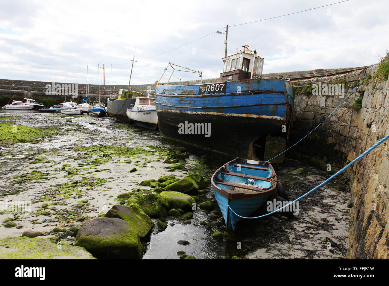 Fishing Boats moored in a small harbour at low tide in Galway Bay Ireland EU Stock Photo