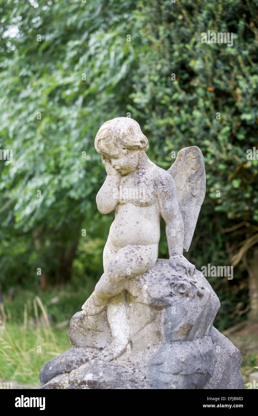 Winged cherub statue in Arnos Vale cemetery, Bristol, England, U.K