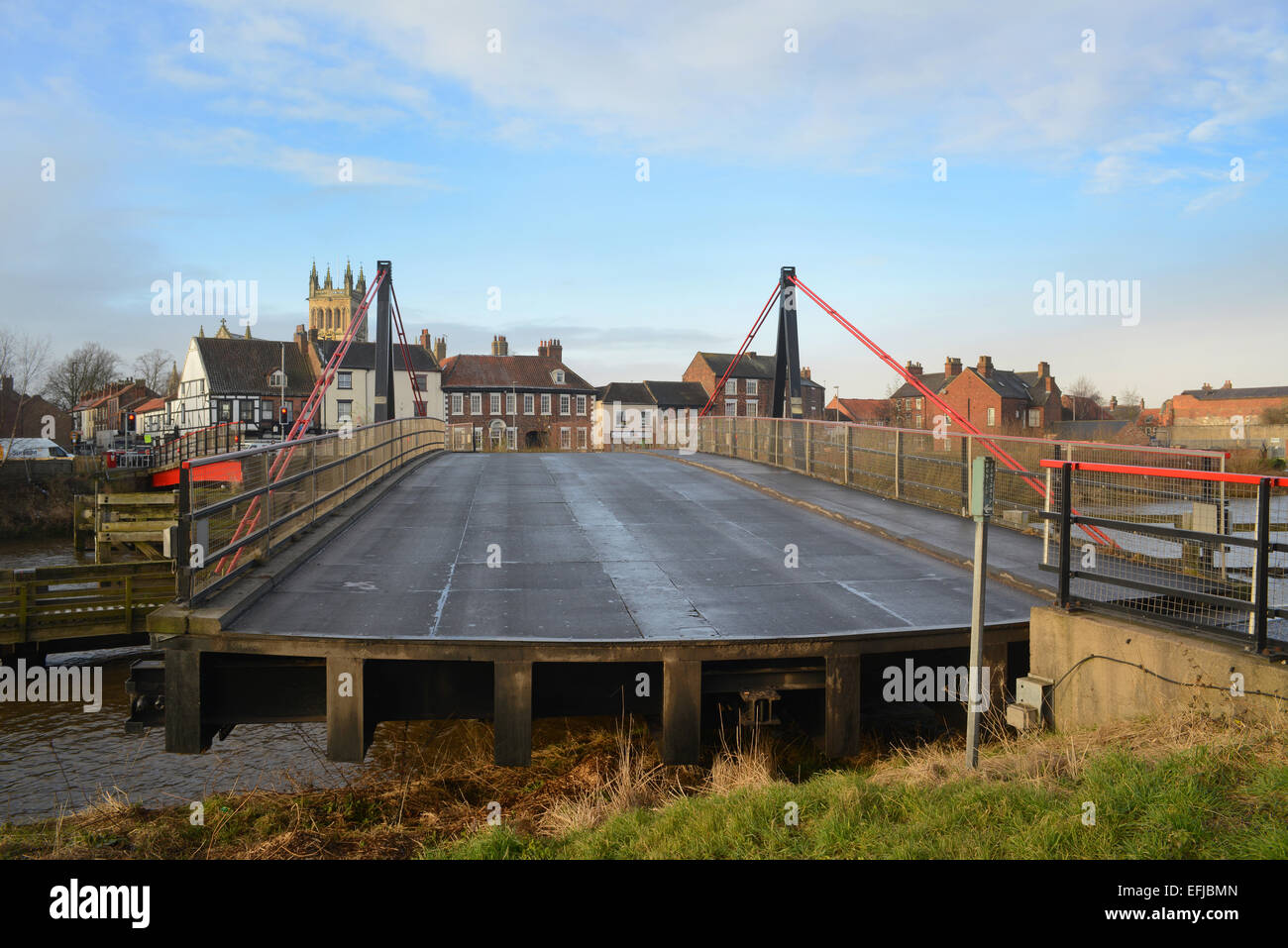 selby road swing bridge closing over the river ouse with selby abbey in the distance yorkshire united kingdom Stock Photo