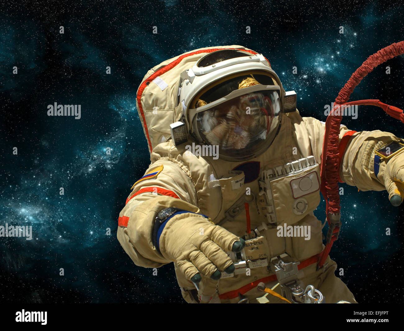 A cosmonaut floats in deep space against a background of stars and nebula. Stock Photo