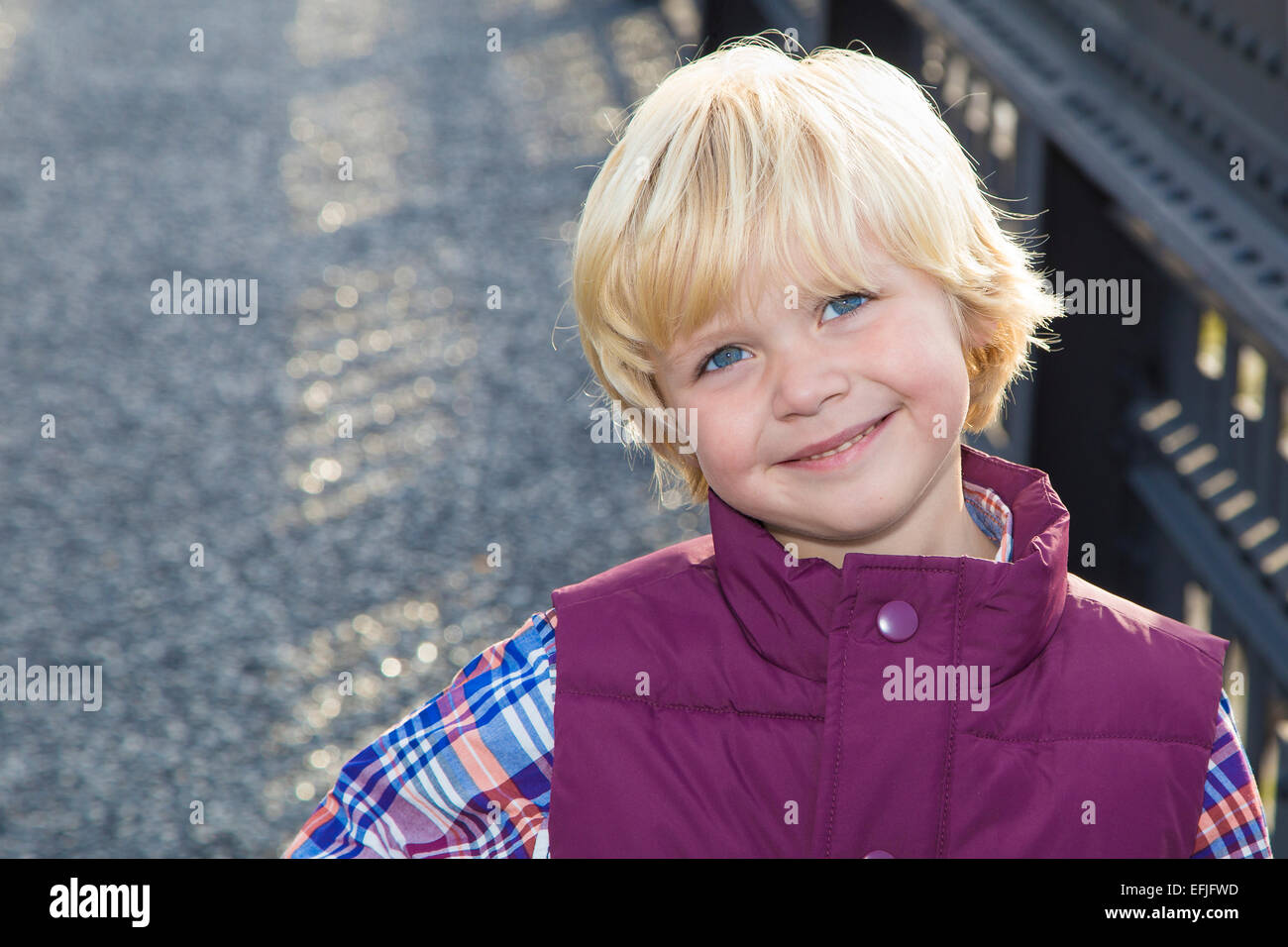 Adorable Happy Blond Boy Portrait with Gravel and Railing Background in Manhattan, NY Stock Photo