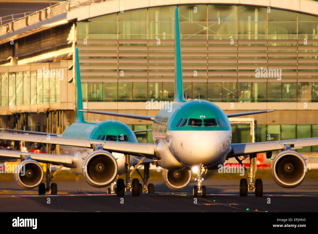 Aer Lingus Airbus A319 lines up on runway 28 at Dublin airport, as a company Airbus A320 follows closely behind. Stock Photo