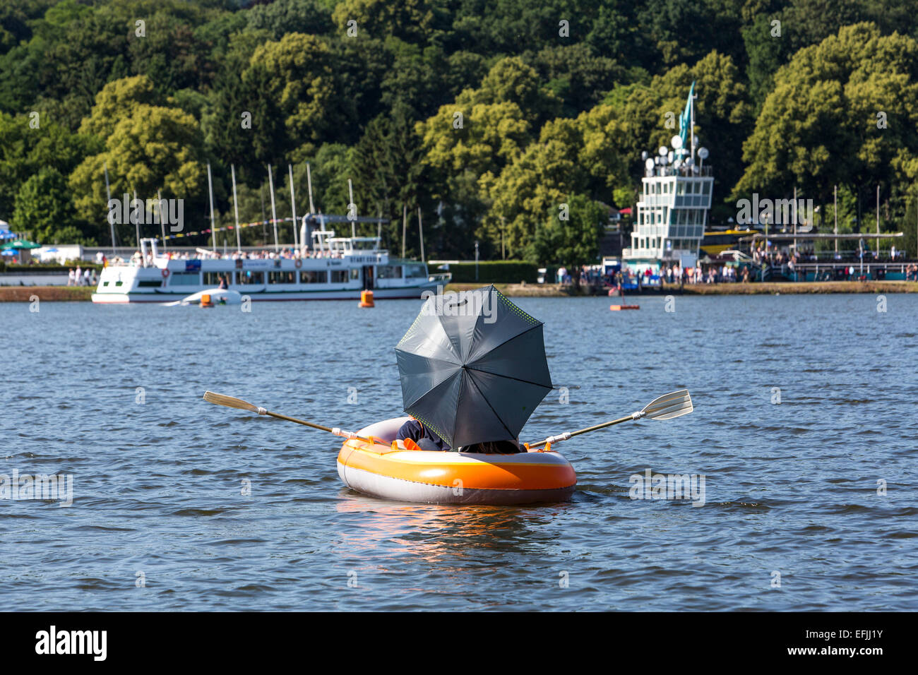 People in a rubber boat, with umbrella, sun bathing, enjoying summer on 'Baldeneysee' lake, Essen, Germany, Stock Photo