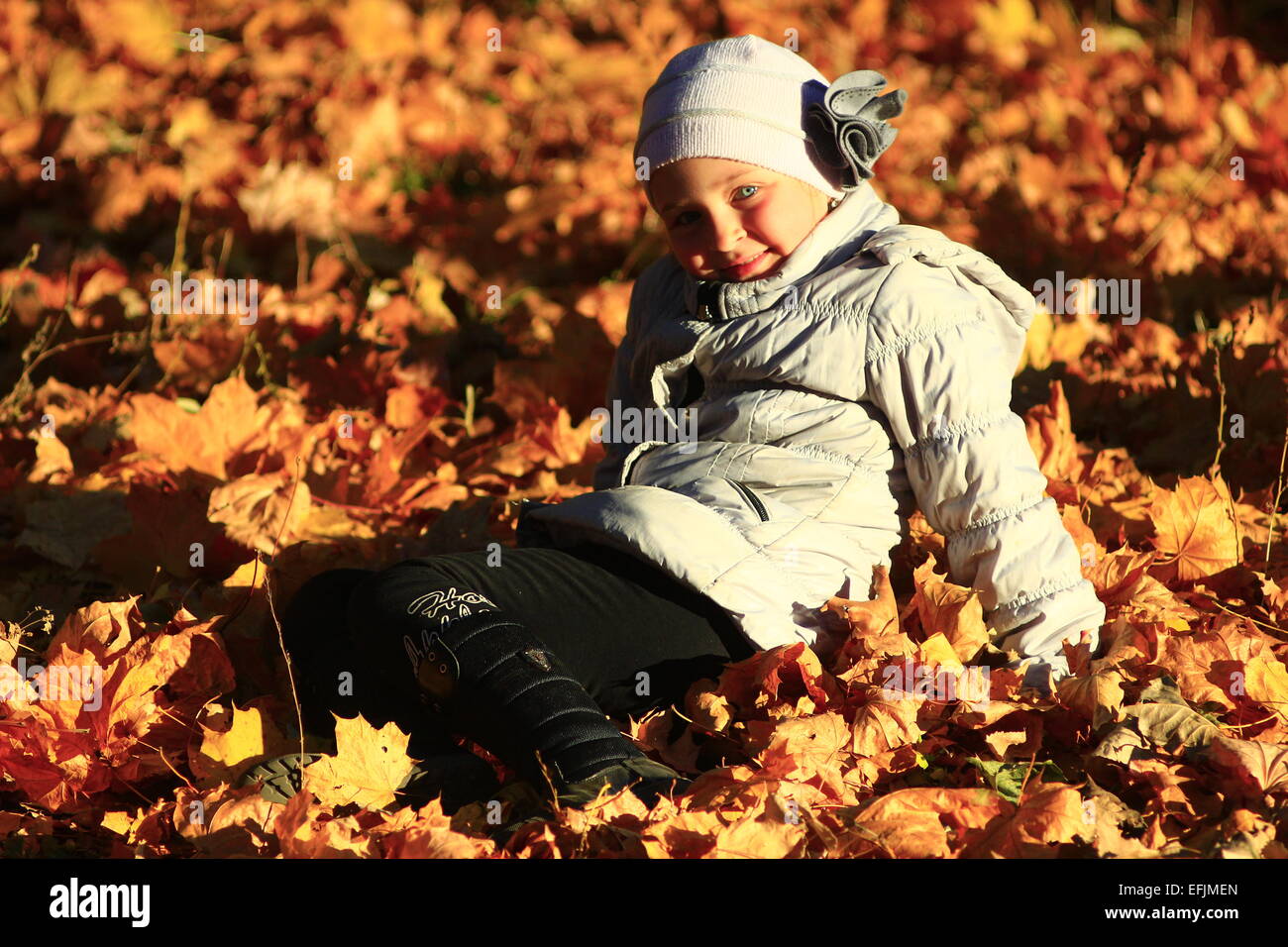 little girl laying in yellow leaves in the autumn park Stock Photo - Alamy
