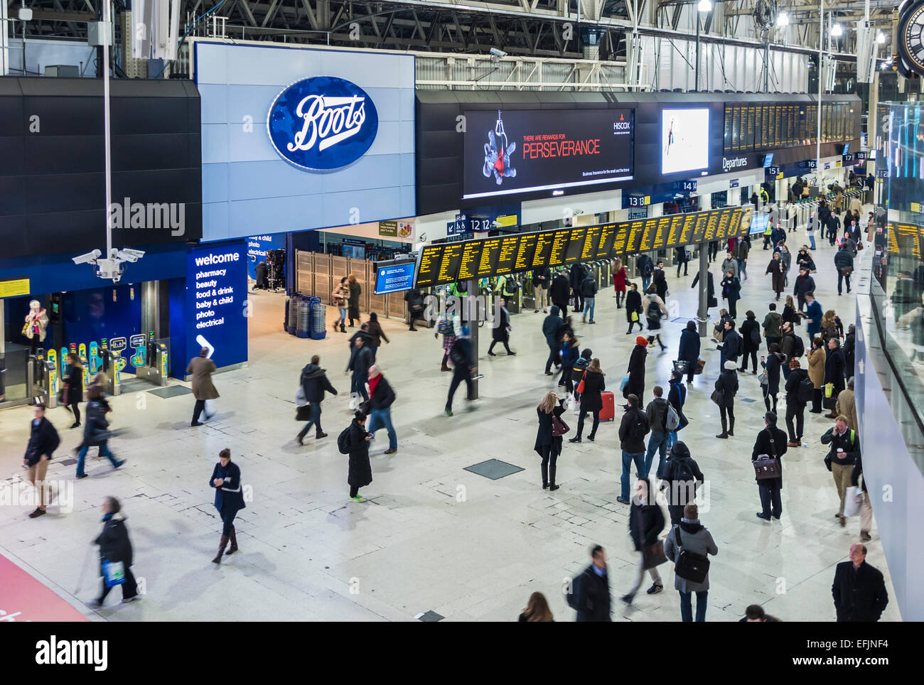 Boots shop sign and logo at London Waterloo Station concourse, crowded