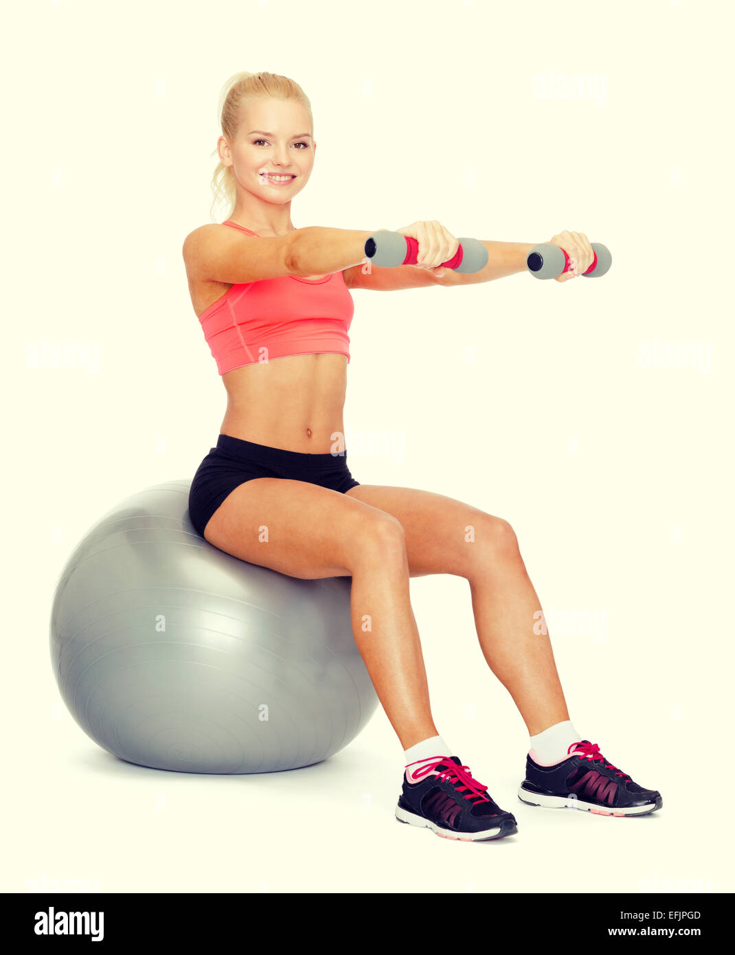woman with dumbbells sitting on fitness ball Stock Photo