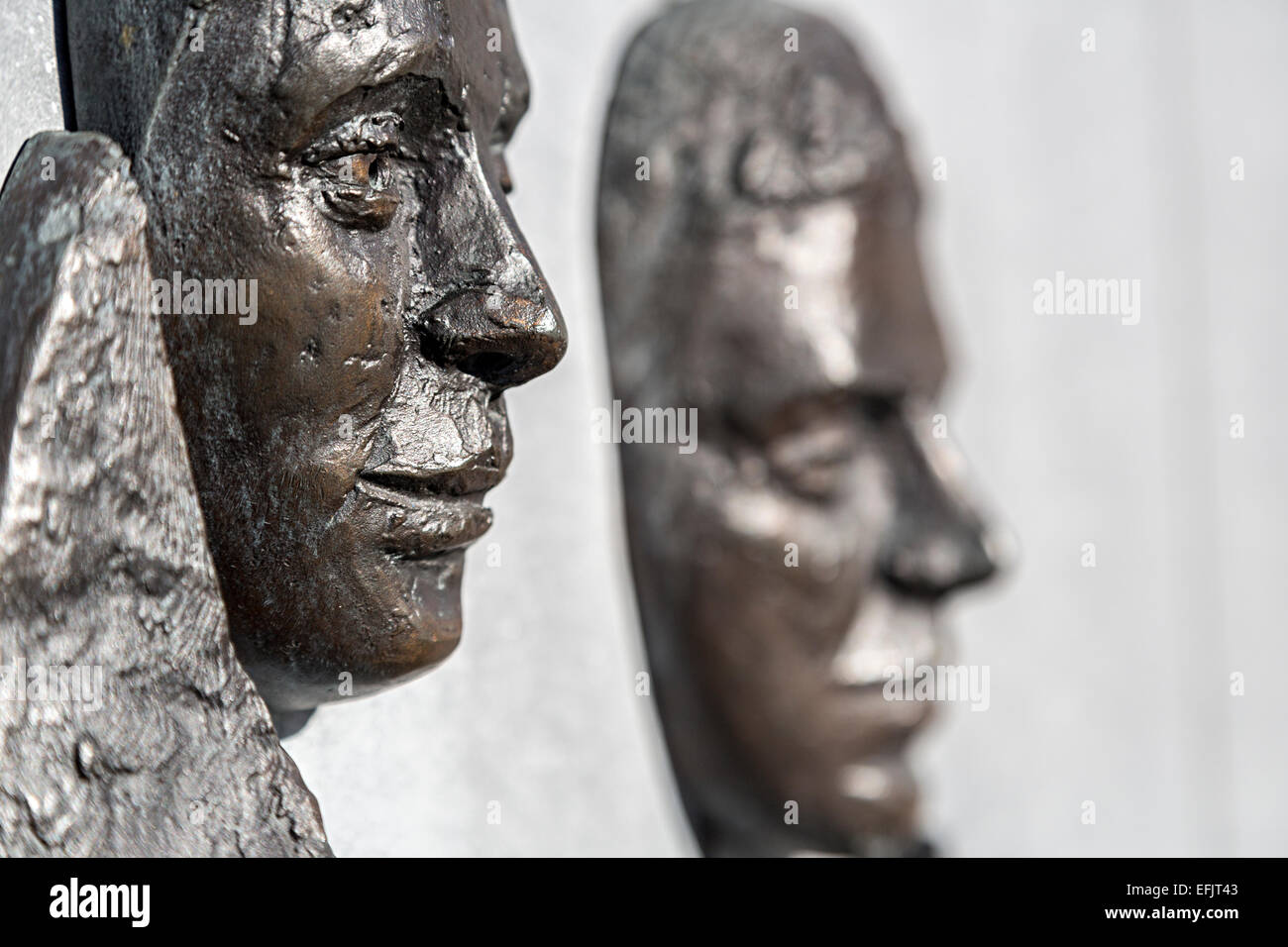 Faces in bronze on the John F. Kennedy memorial on quayside at New Ross, Co. Wexford, Republic of Ireland Stock Photo