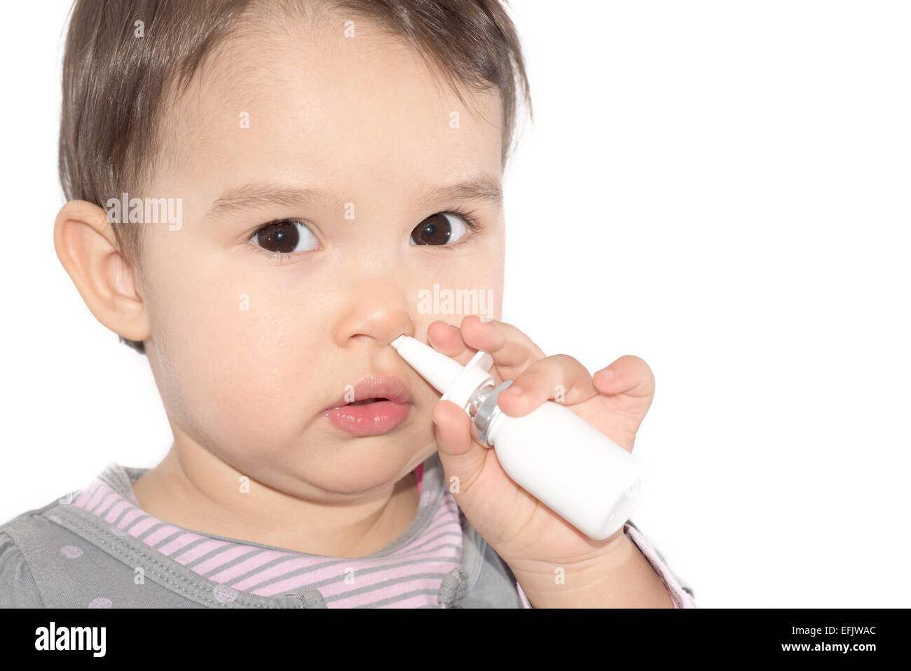 little girl using nasal spray - white background Stock Photo