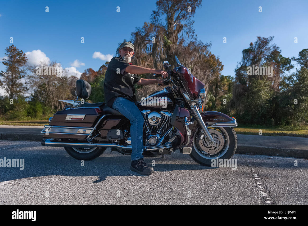 Man posing on his 2007 Harley Davidson Ultra Glide Motorcycle in Central Florida USA Stock Photo