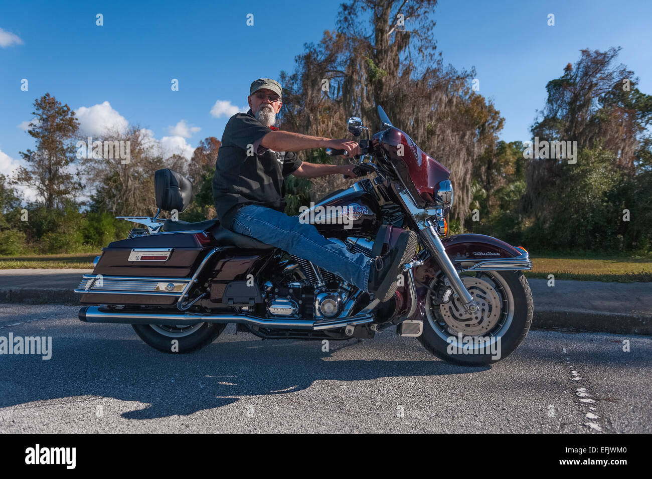 Man posing on his 2007 Harley Davidson Ultra Glide Motorcycle in Central Florida USA Stock Photo
