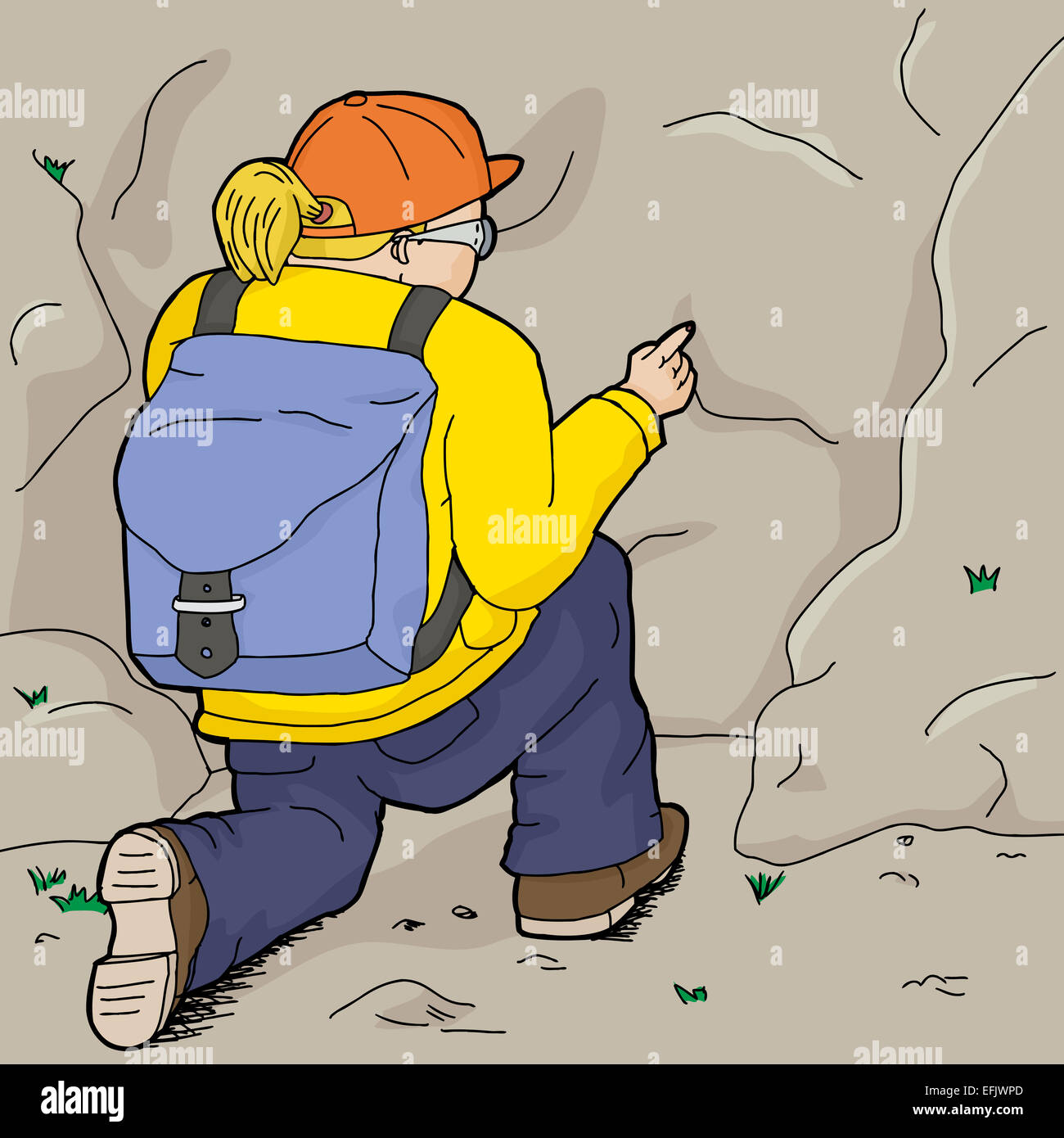 Hiker in yellow kneeling and pointing at rock Stock Photo